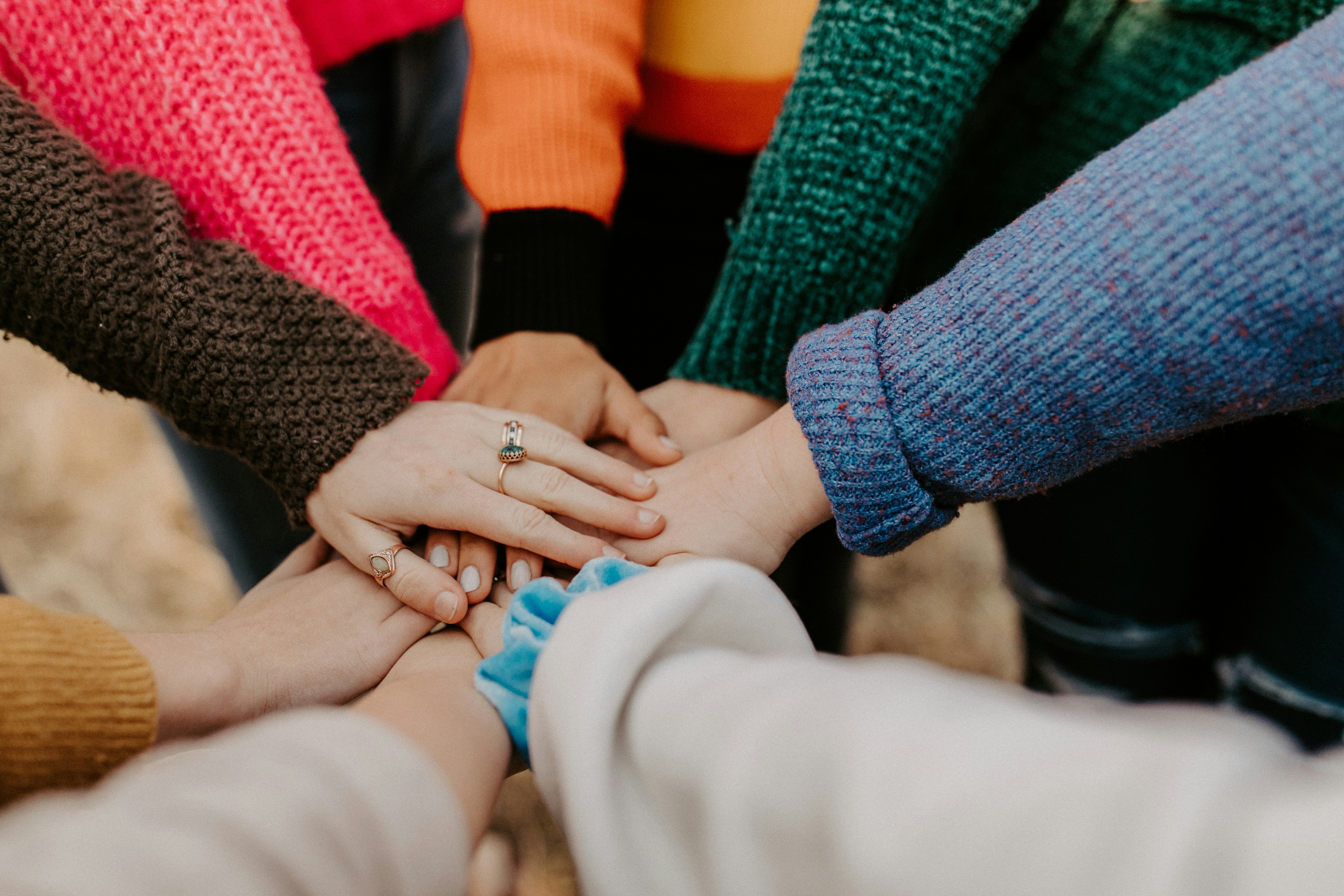 People with joined hands in a show of teamwork and collaboration